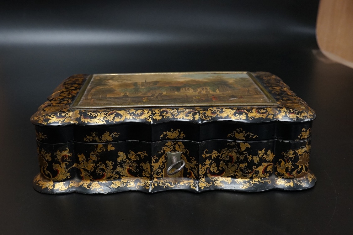 A Victorian Papier mache japanned sewing box, stamped ‘Lane, Birmingham’, the cover with a view of Chingford old church Essex, a boxed Victorian French translation game, by E C Spurin and a papier mache panel (3)